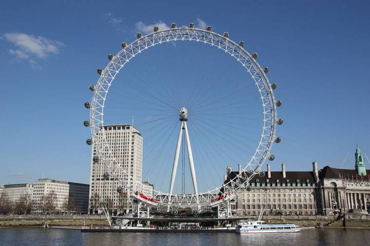 a large ship in a body of water with London Eye in the background